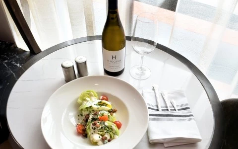 a plate of salad and wine bottle on a table42