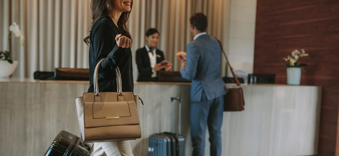 woman with a purse walking through the lobby of the hotel 