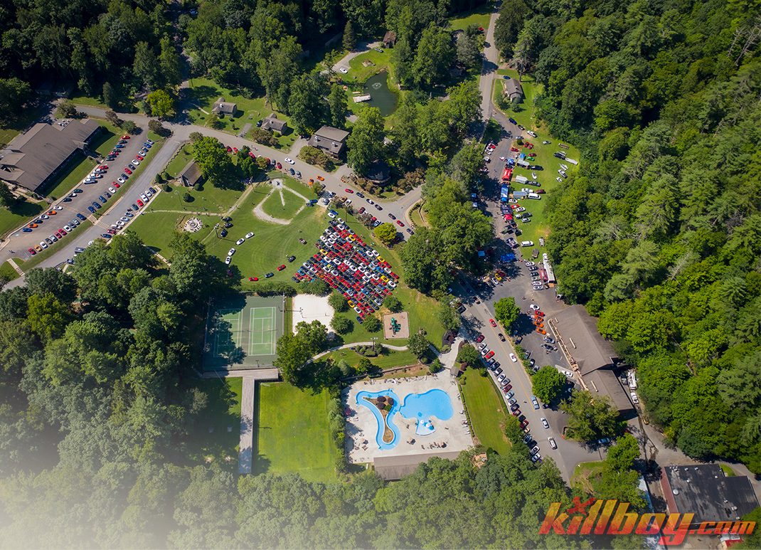 aerial view of a park with cars and a pool