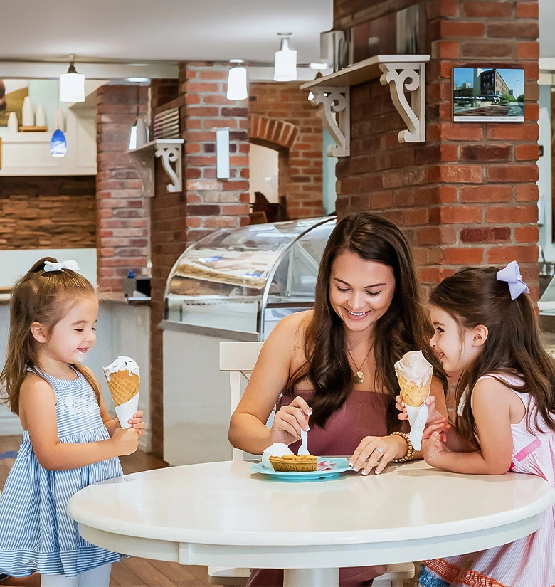 a woman and two girls eating ice cream
