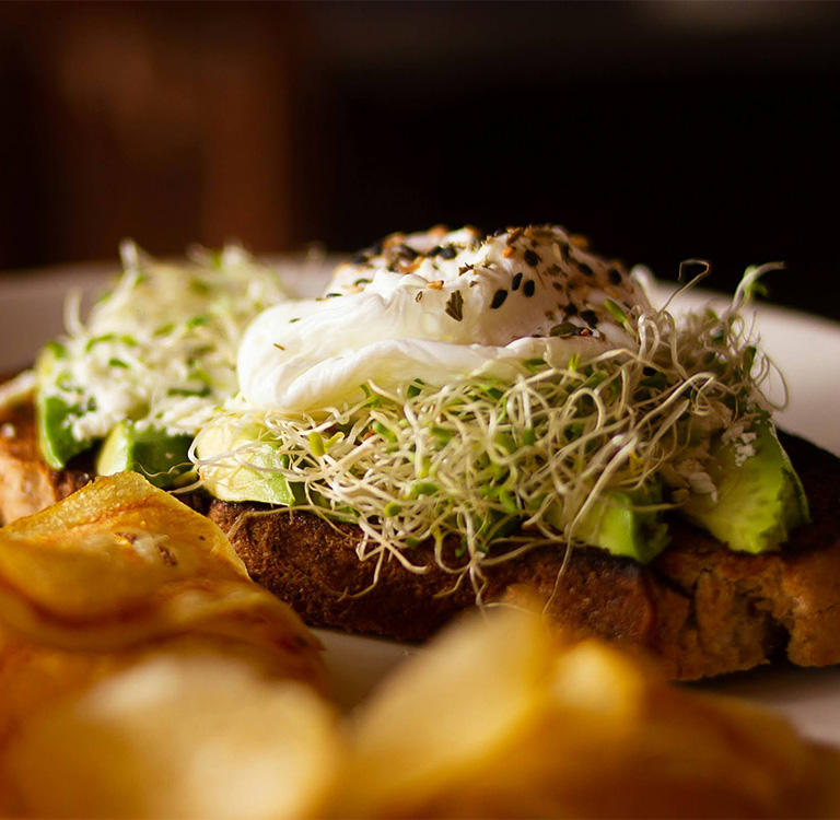 a plate of food with a poached egg and sprouts