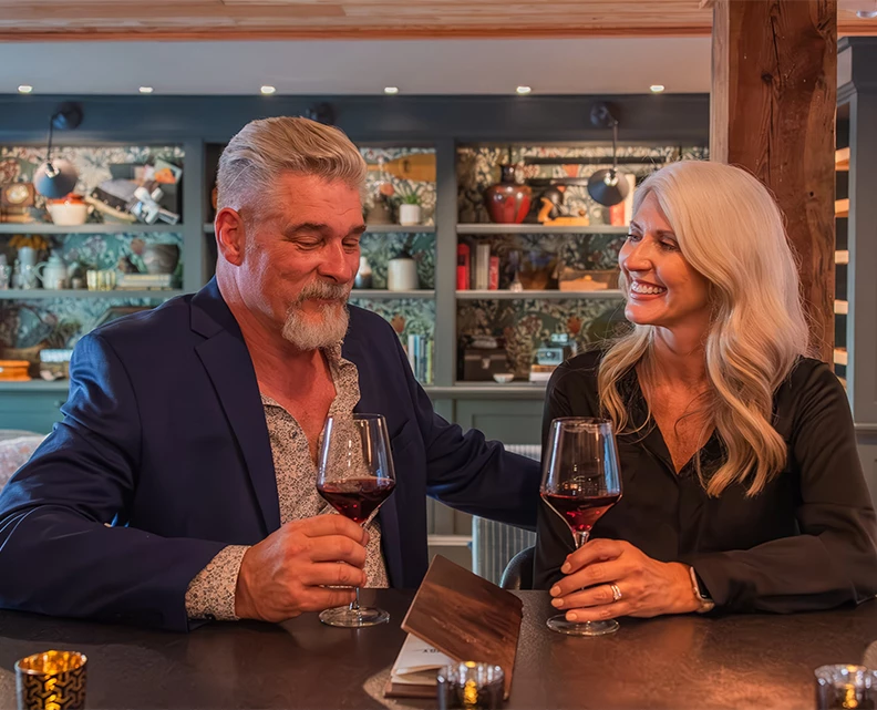 a man and woman sitting at a table with wine glasses