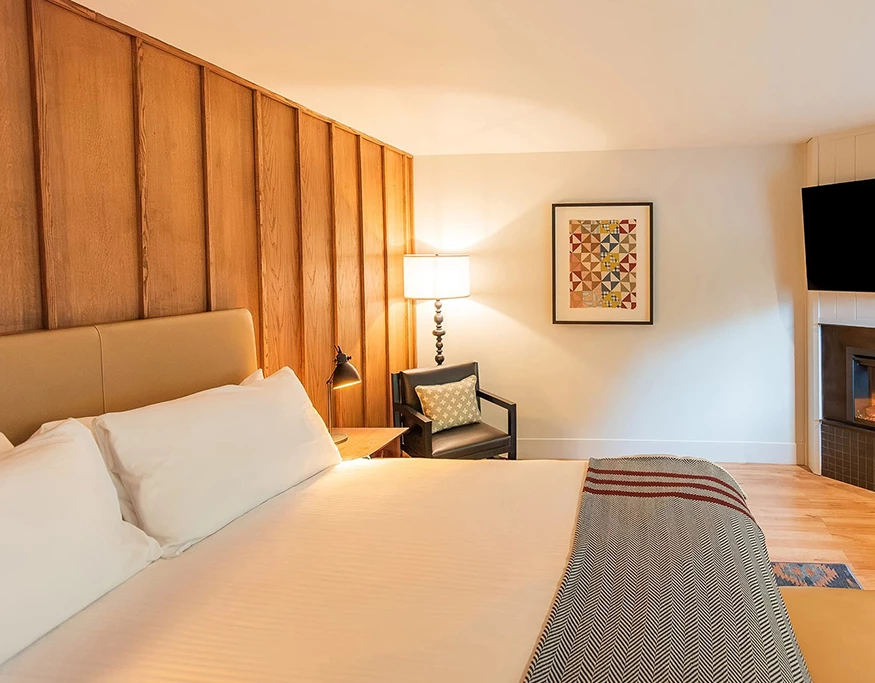 a bed with a lamp and a picture on the wall