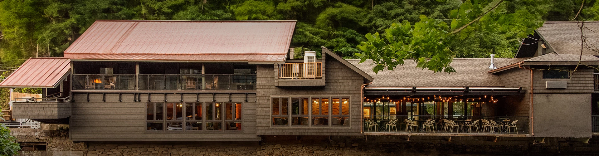 a house with a balcony and trees in the background
