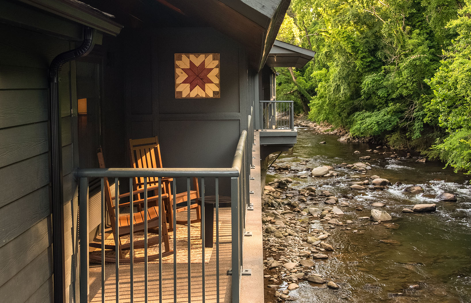 a house with a river and a bench