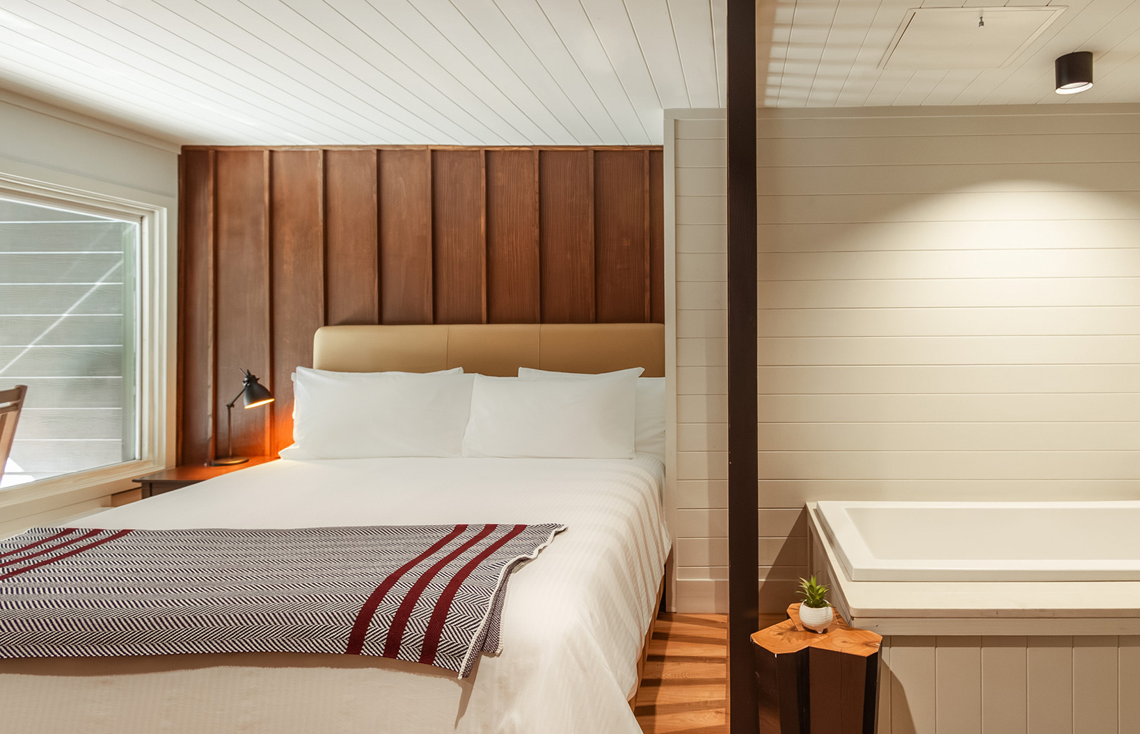 a bed with a bathtub and a lamp