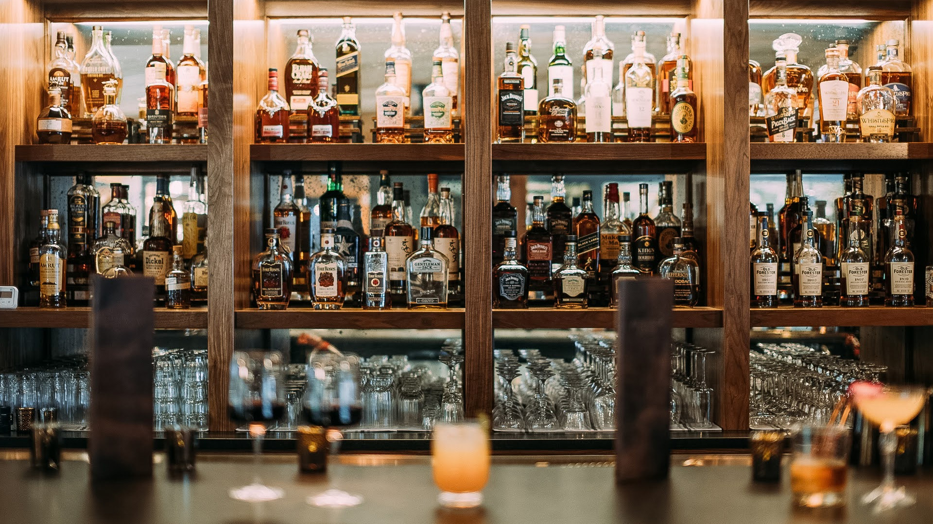a shelf with bottles and glasses