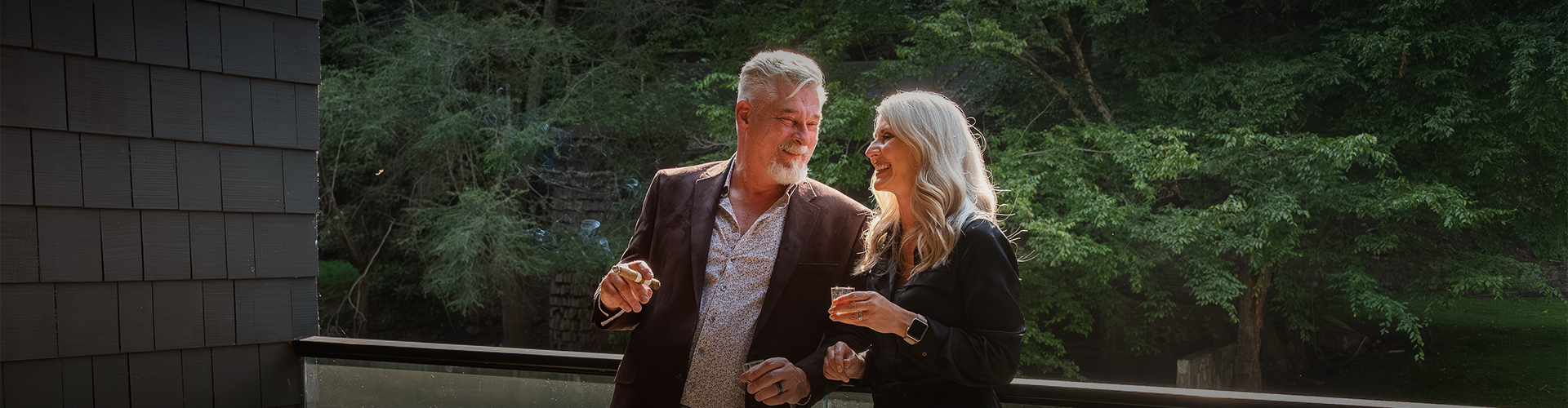 a man and woman holding drinks and cigars