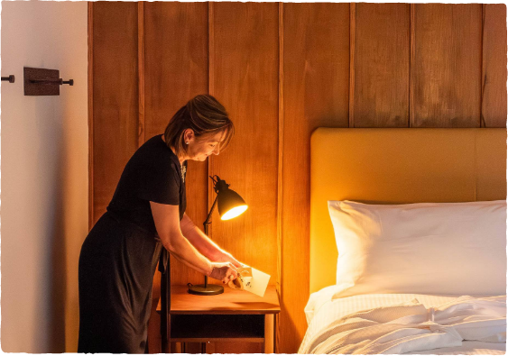 a woman standing next to a bed