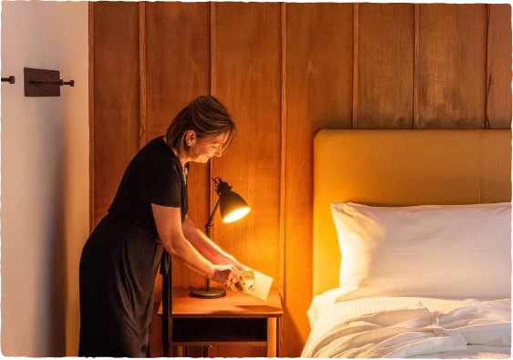 a woman standing next to a bed