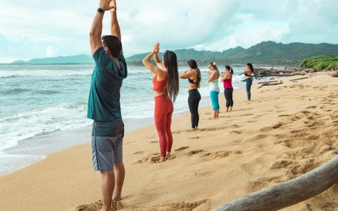 guys aligned doing some yoga at the beach