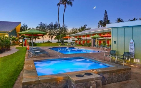 View of two pools next to some hotel rooms at sunset