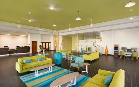 Internal view of a waiting room full of tables and sofas of bright colors