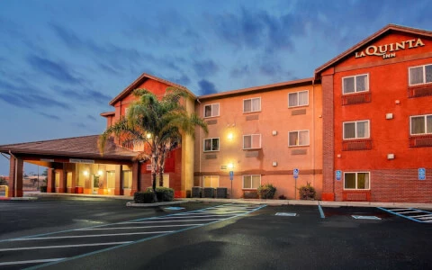 hotel exterior with orange paint lit up during sunset