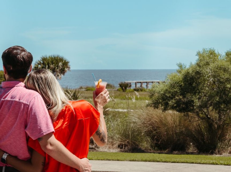 a man and woman hugging and holding a drink