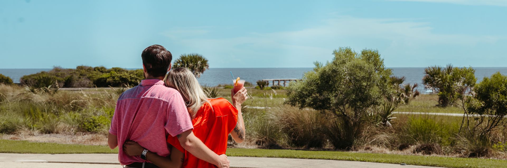 a man and woman hugging and holding a drink