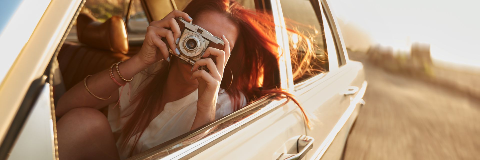 a woman holding a camera in a car