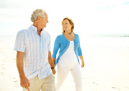 Mid-age couple taking a walk on the shore of the ocean 