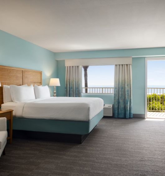 a hotel room with a bed and a balcony