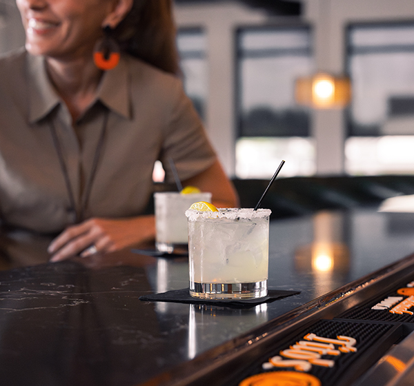a woman sitting at a bar with a drink