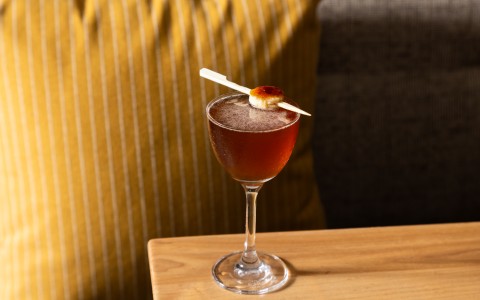 a glass of liquid with a toothpick on top