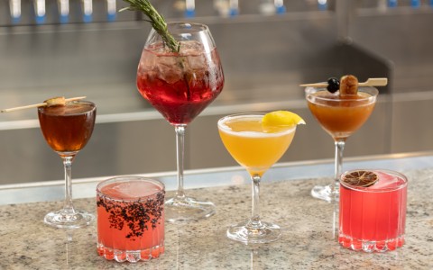 a group of different colored drinks on a counter