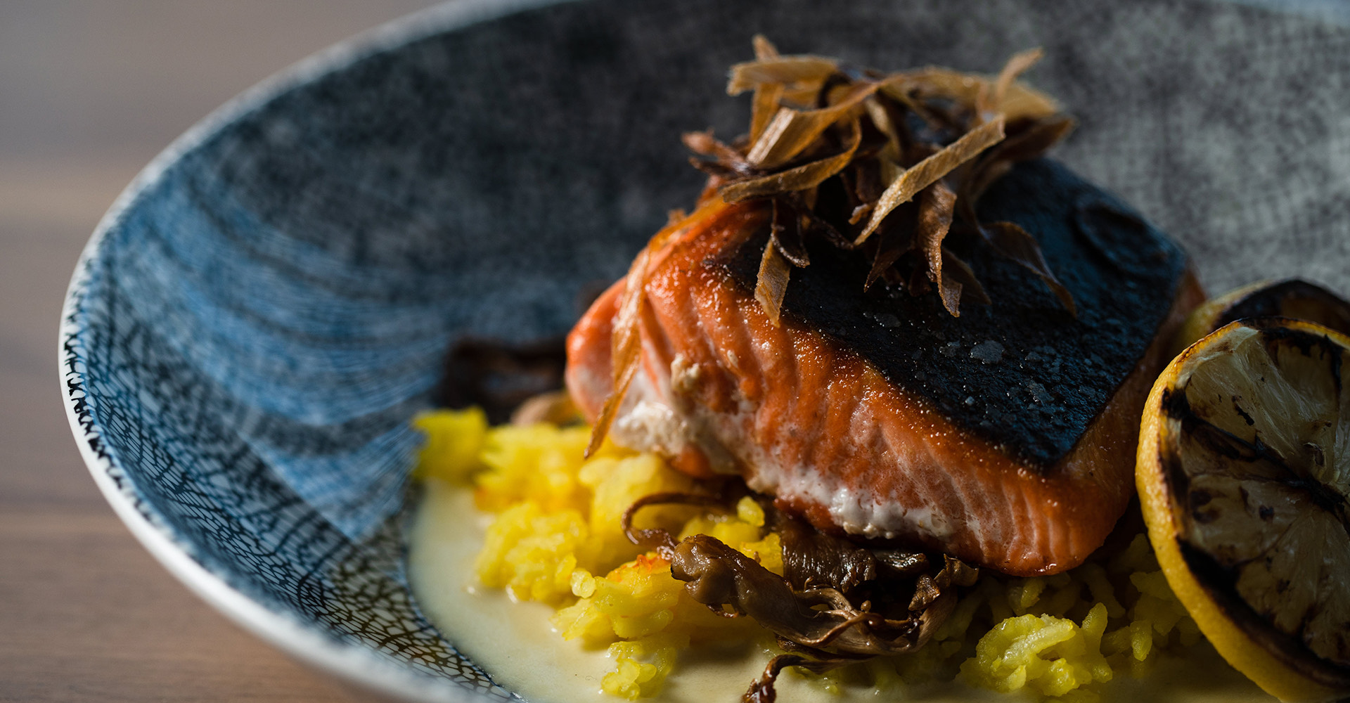 Plated salmon sitting on yellow rice