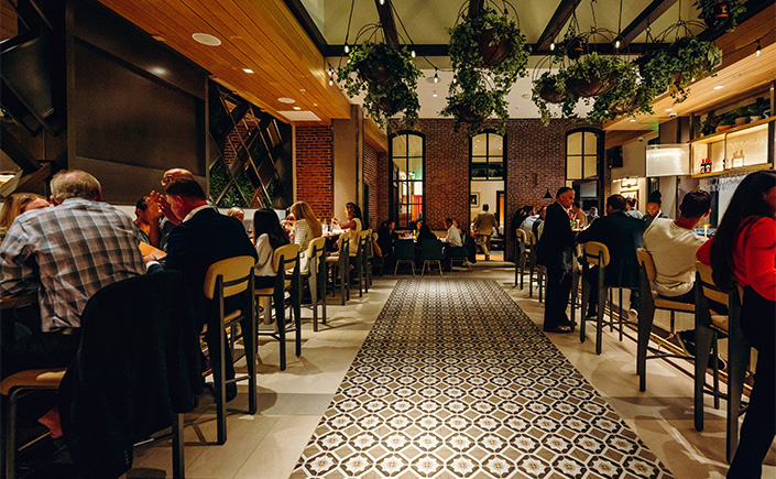 a group of people sitting at tables in a restaurant