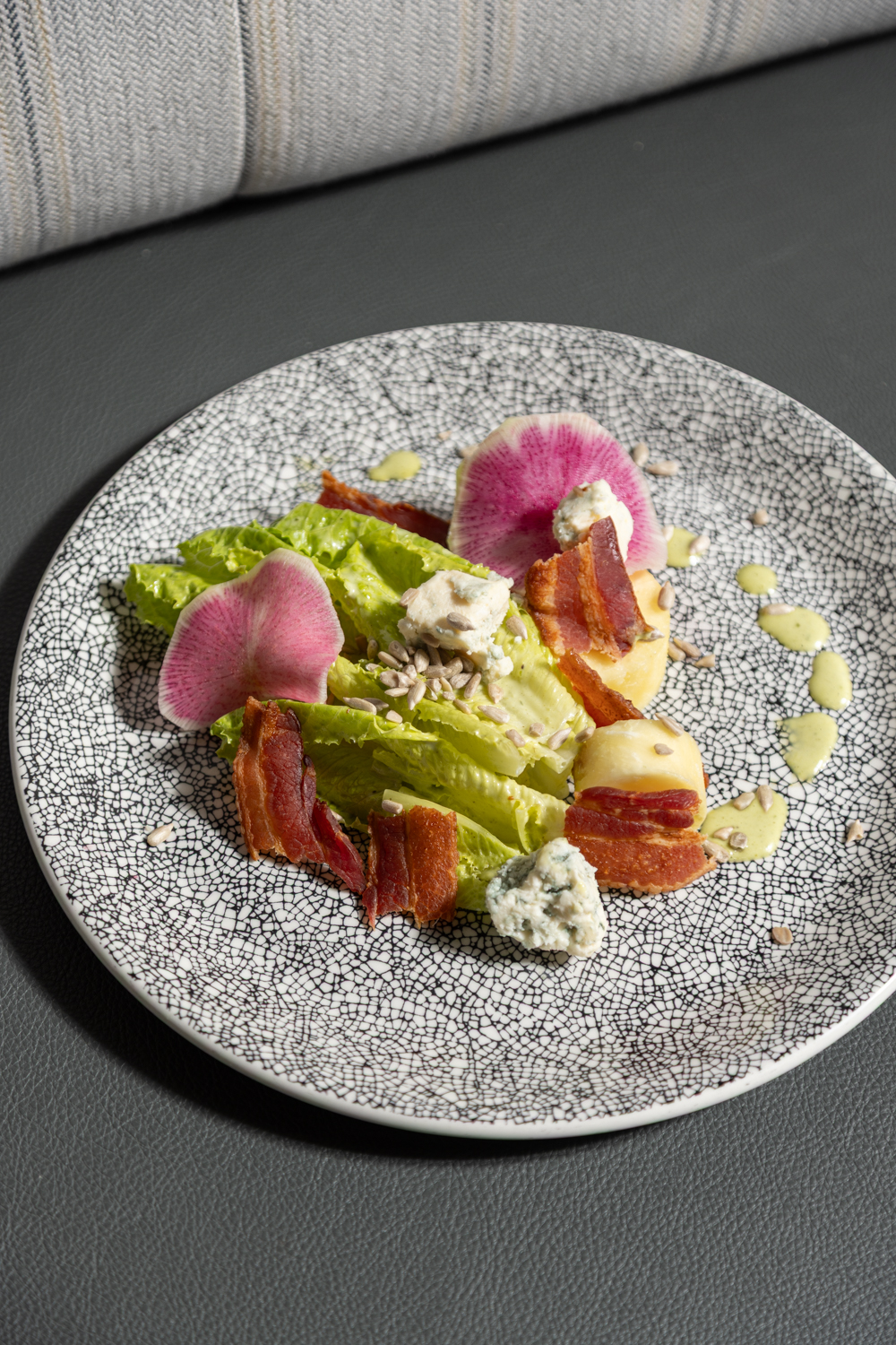 a plate of salad with bacon and radish