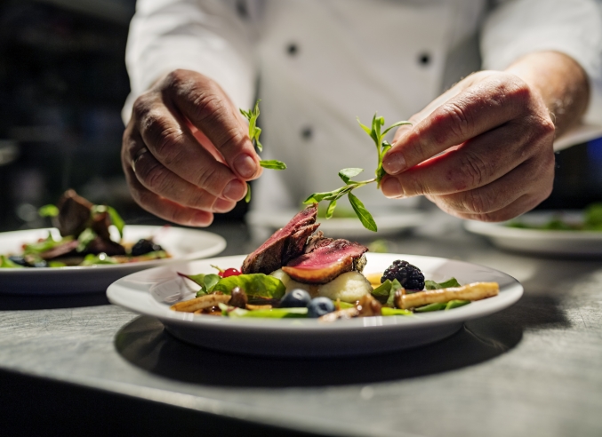 a chef preparing food on a plate