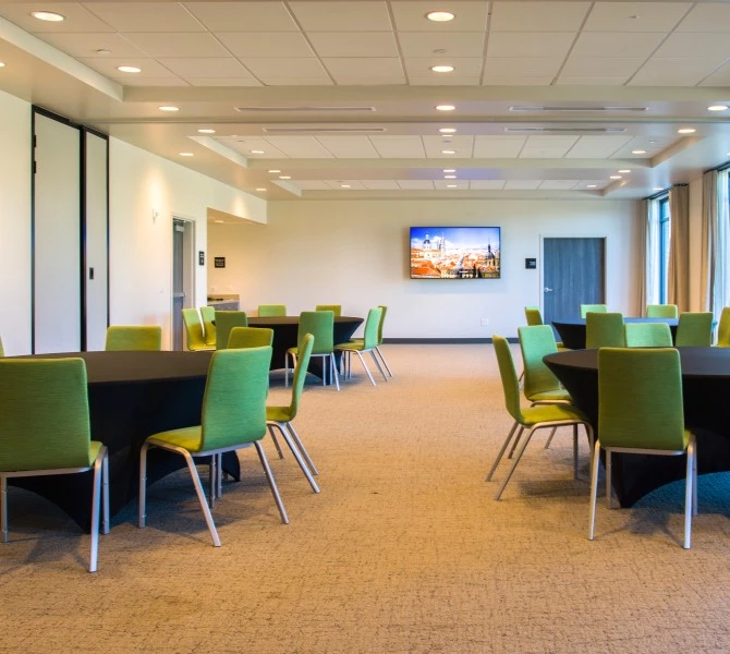 a room with a black table and green chairs