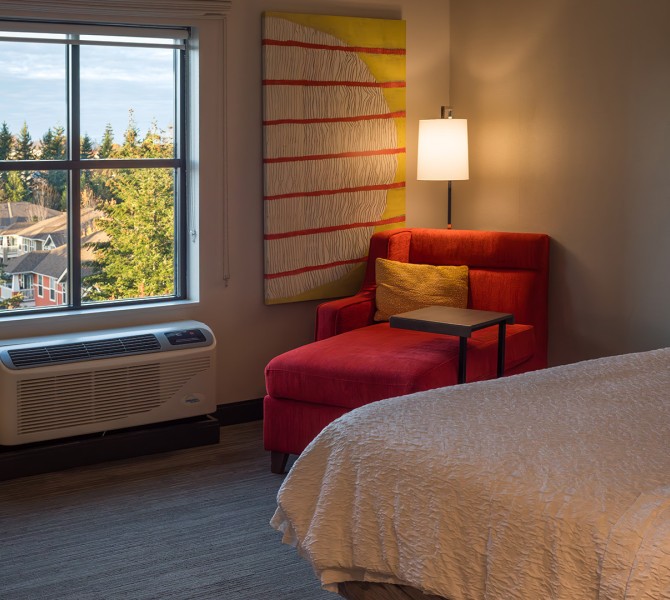 a room with a bed and a red chair