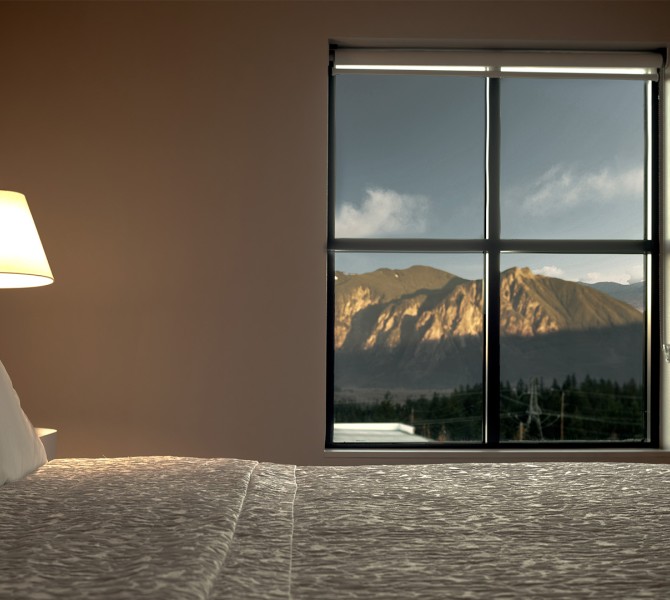 a lamp on a bed next to a window