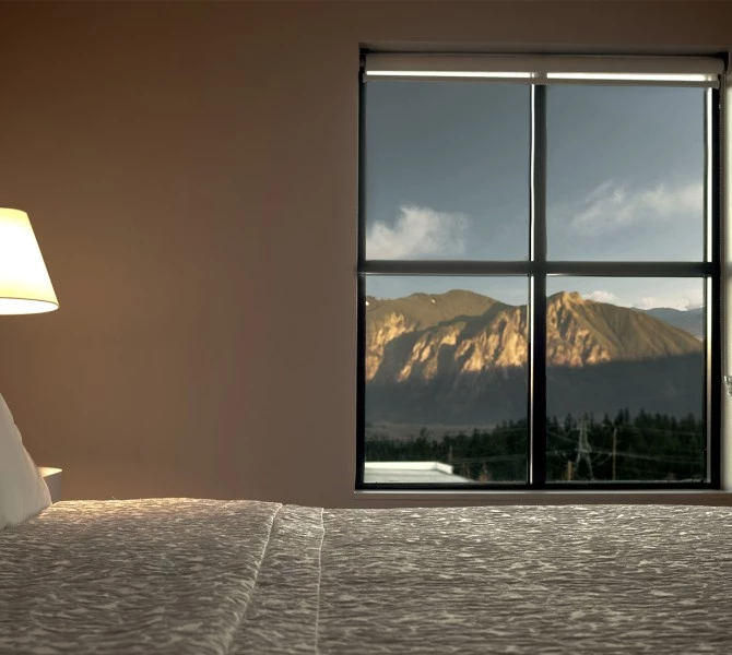 a lamp on a bed next to a window
