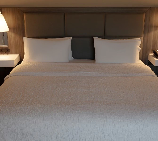 a bed with white sheets and pillows