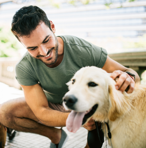 guy bending down petting his dog