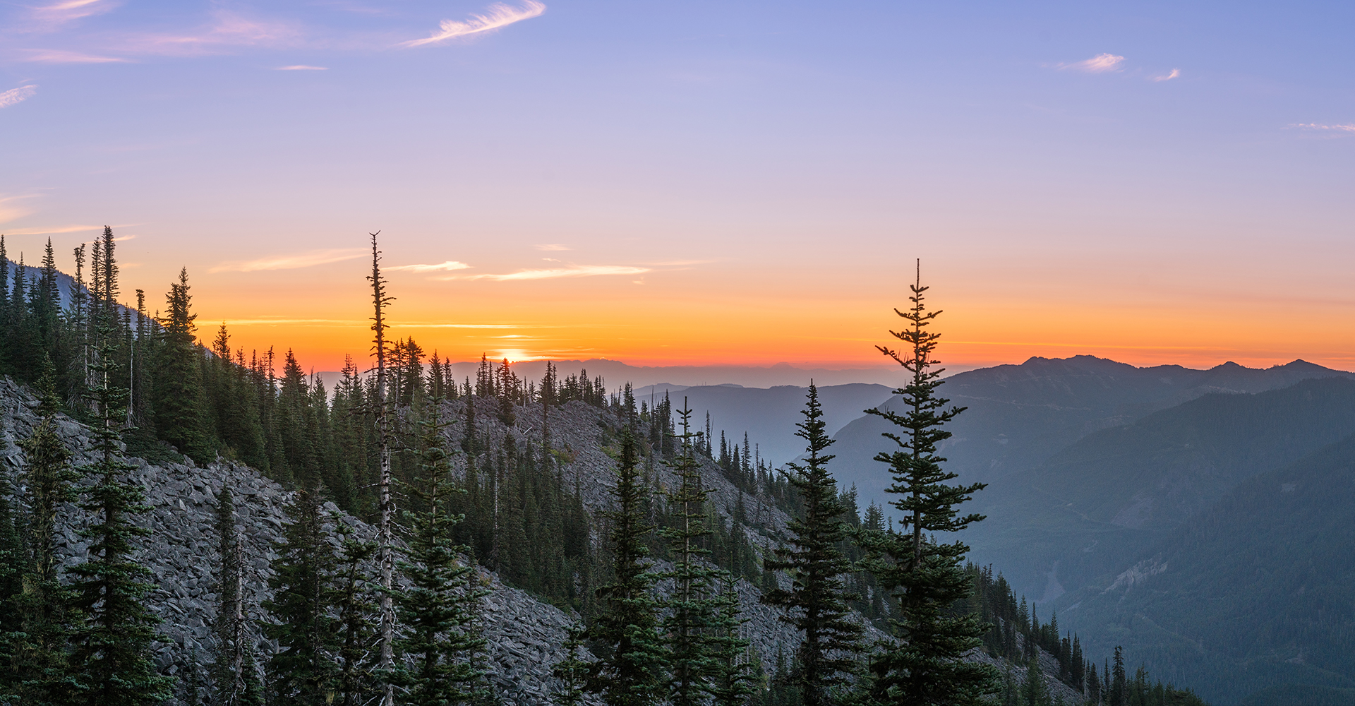 the sun setting behind the mountains