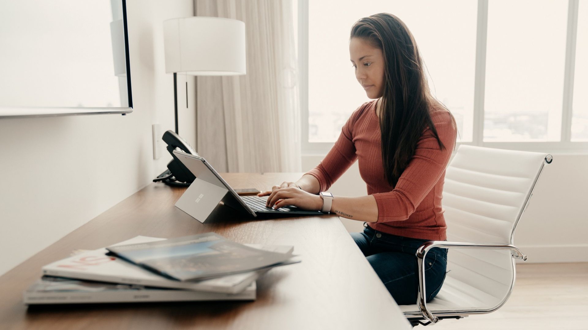 a woman sitting at a desk using a laptop