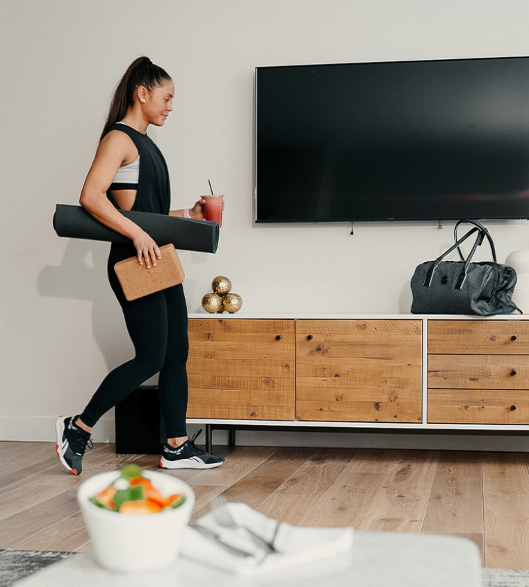 a woman walking in a room with a tv