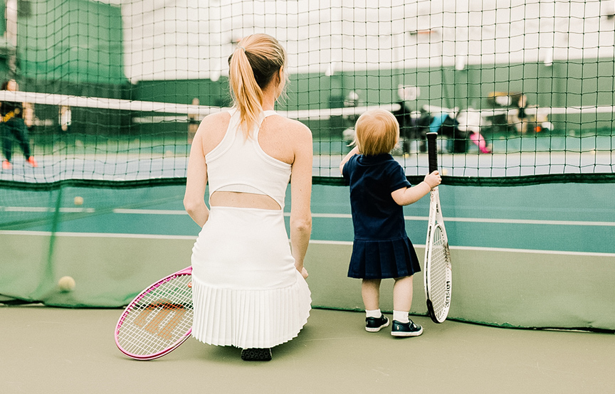 a woman and a child holding tennis rackets
