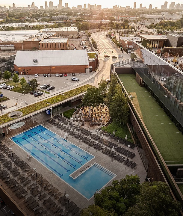 a swimming pool and a building with cars and buildings in the background