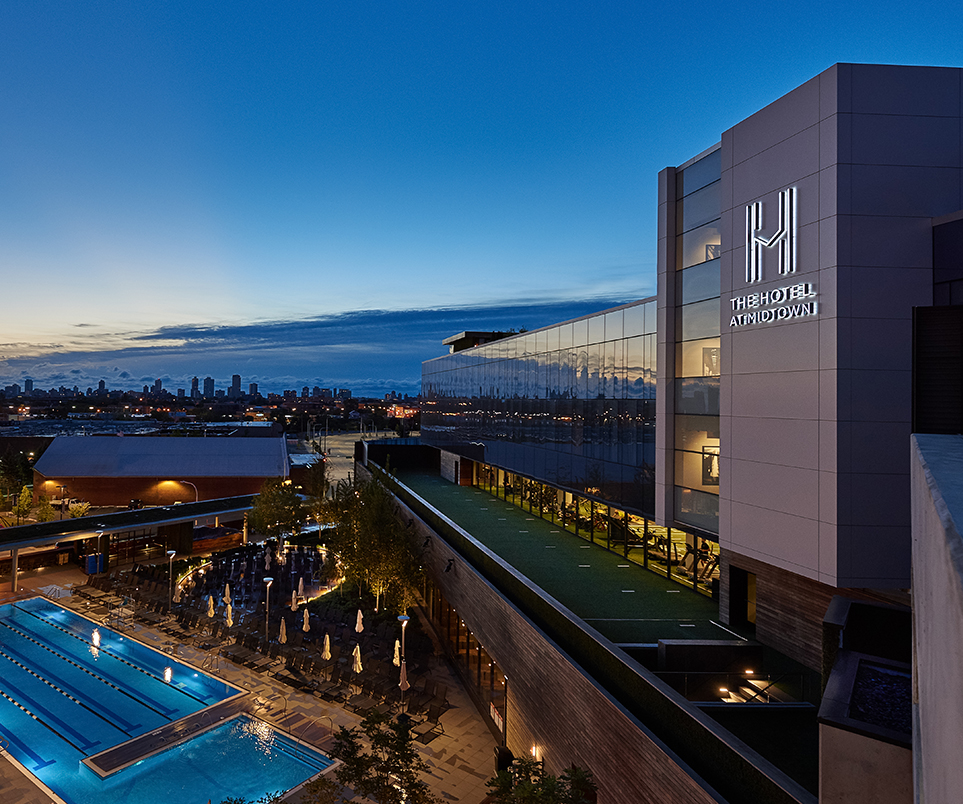 a building with a pool and a city in the background