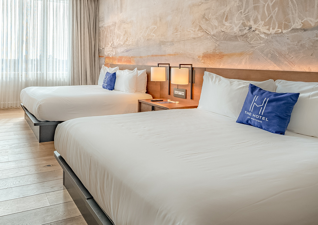 a room with two beds and a lamp