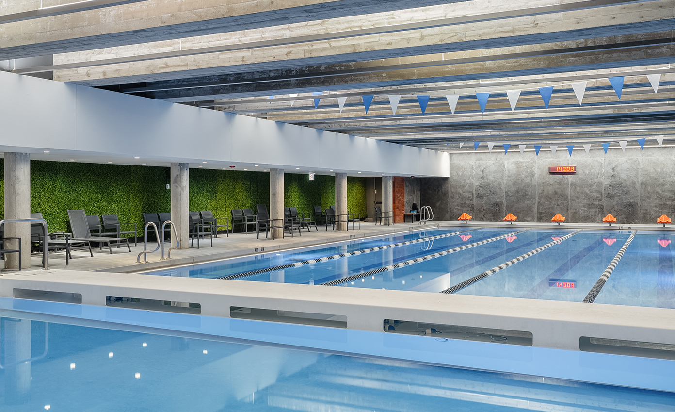 a indoor swimming pool with a concrete wall and flags