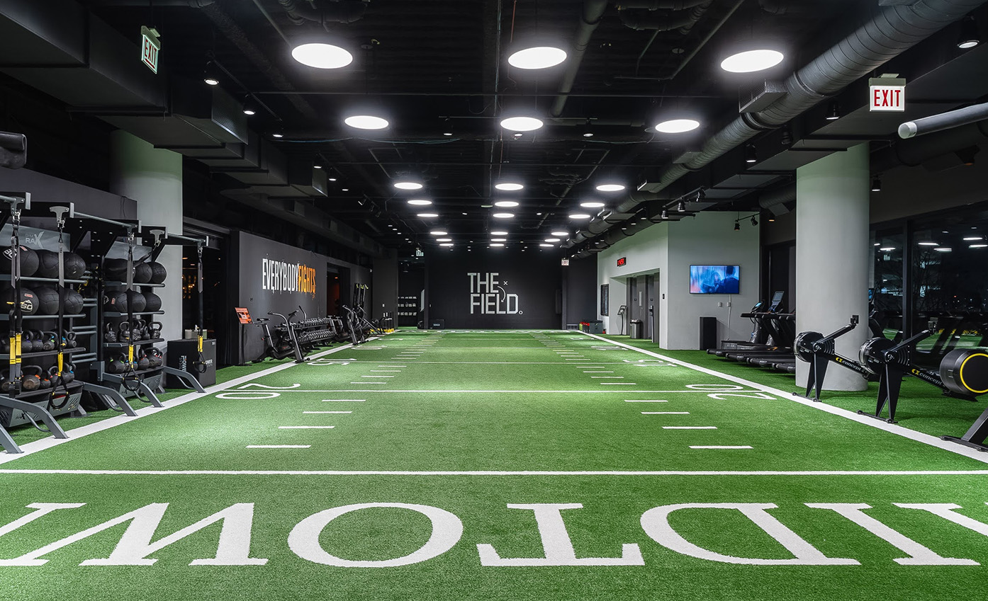 a indoor football field with a green field and white text