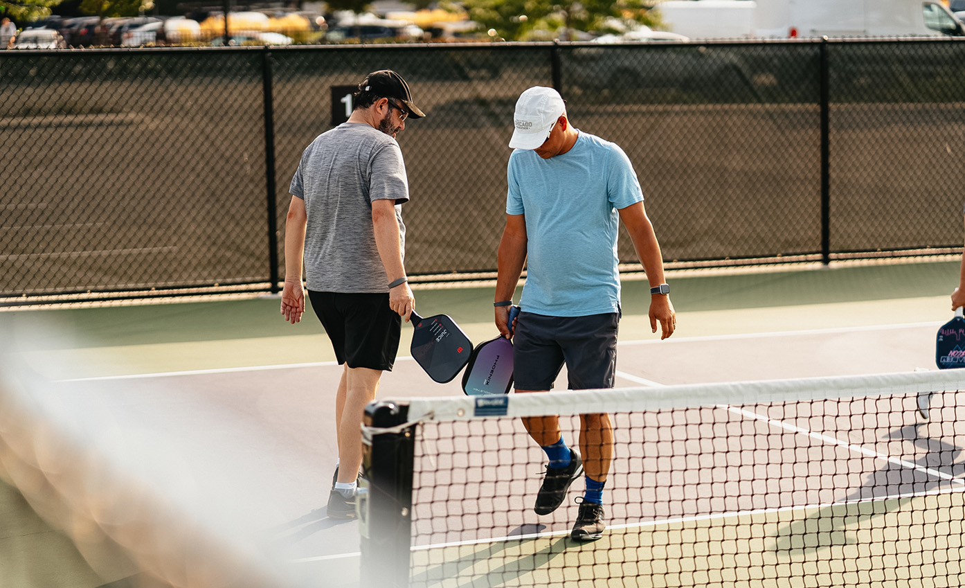 two men holding paddles on a tennis court