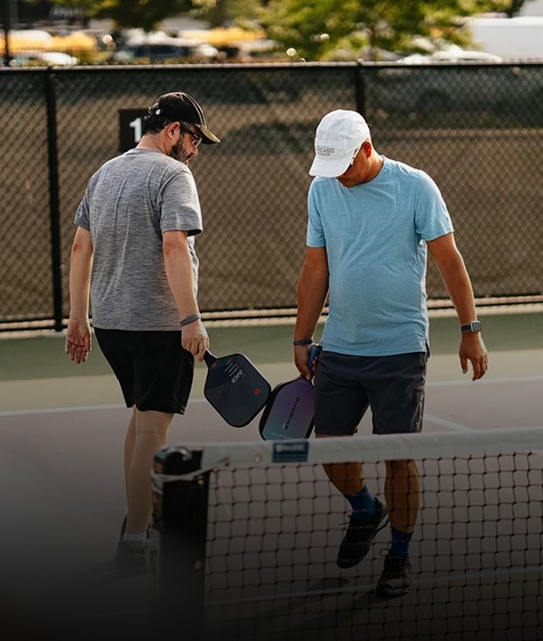 two men holding paddles on a tennis court