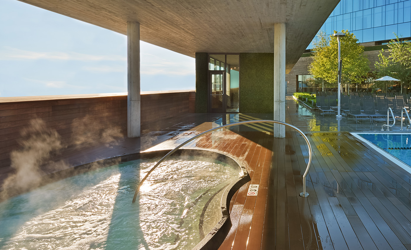 a hot tub with a railing on a deck