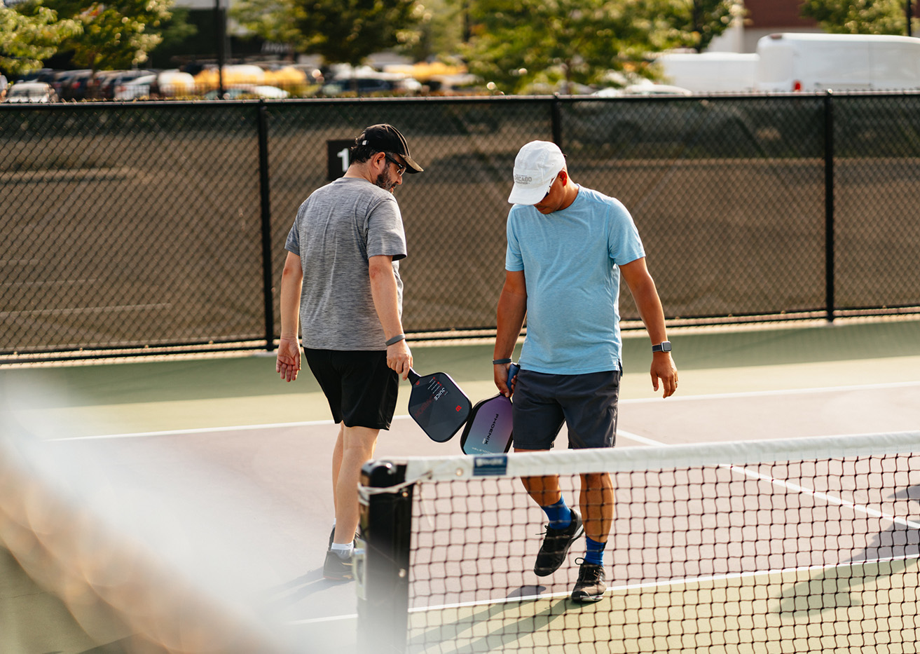 two men holding paddles on a tennis court