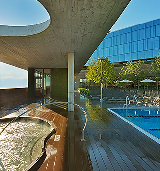 a pool with a hot tub and a building